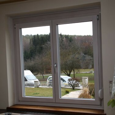 Neu eingebautes, weißes Fenster mit Blick ins Grüne